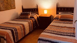 A room with two beds, a wall tapestry, a hanging lamp, and a textured ceiling. - Self catering Barranco de la Salud for 4 people (Nevada)