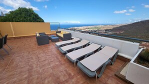 Une terrasse avec des places assises extérieures et une vue sur la mer.
