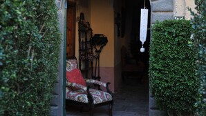 Un ingresso ad arco con una panchina e una sedia all'interno.