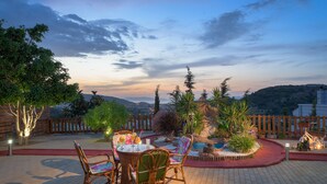 An outdoor patio with wicker furniture, a small table, and a decorative garden area. - Dreamcatcher Villa with private pool (Pastida)