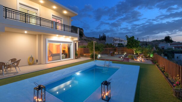 A modern house with a swimming pool, outdoor furniture, and a well-lit balcony. - Dreamcatcher Villa with private pool (Pastida)