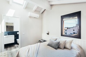 Relax in a spacious bedroom with a large bed and a window offering a view of the outside.