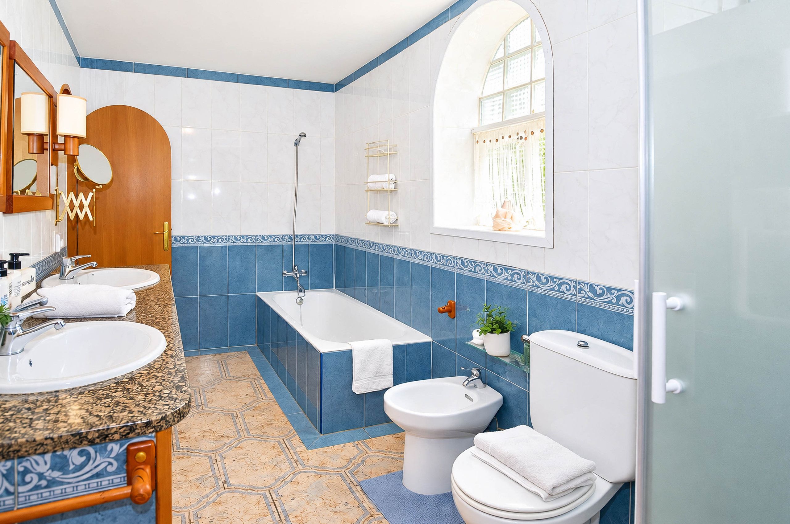 Un baño con bañera, dos lavamanos, inodoro y ducha.