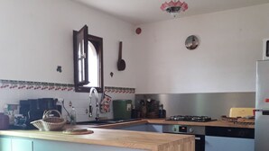 Une cuisine dotée d’un îlot central, d’une cuisinière, d’un évier et d’un réfrigérateur.