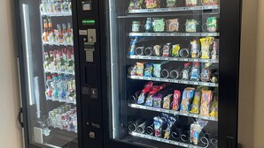Deux distributeurs automatiques proposant une variété de boissons et d’en-cas.