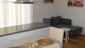 Ett modernt kök med en matplats, en soffa och konstverk på väggen.