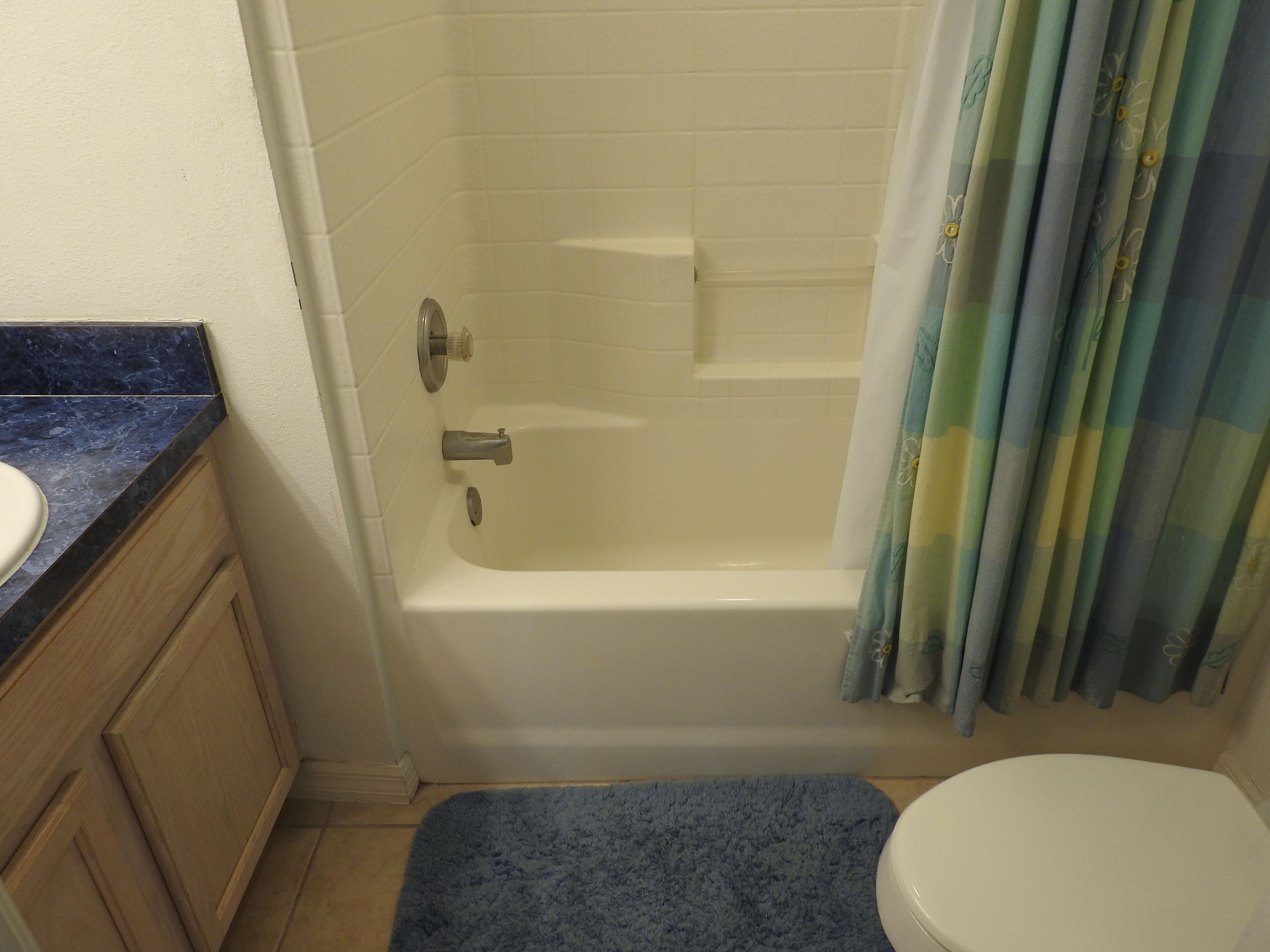 A bathroom with a bathtub, a toilet, and a sink.