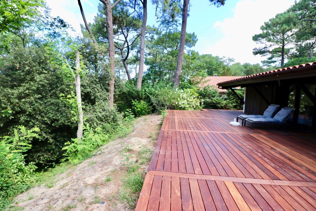 A wooden deck with a built-in seating area and a covered section.