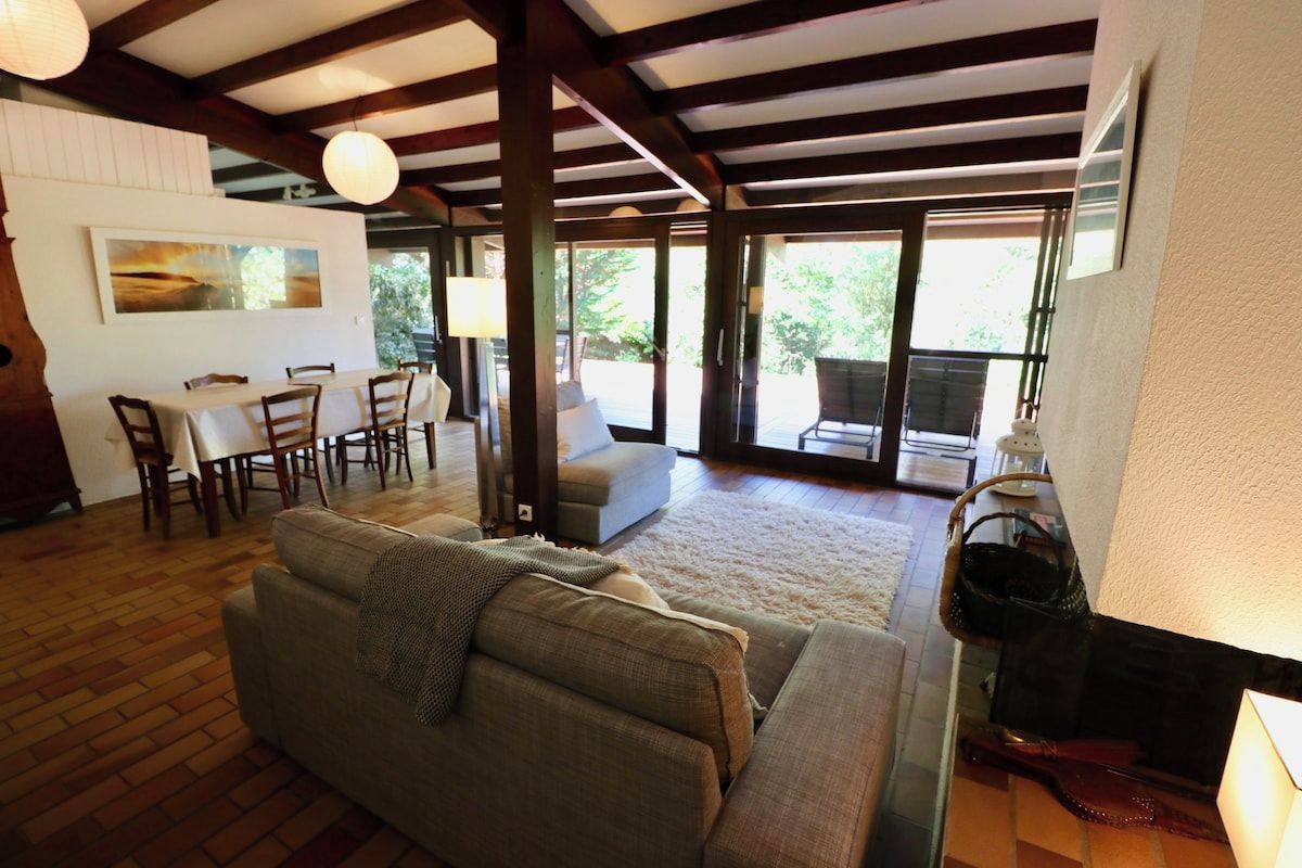 A spacious living area with a sofa, dining table, and chairs.
