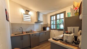 A compact kitchen with a dishwasher, microwave, and toaster. - BUNGALOW T3 PITAYA (Saint-Paul)