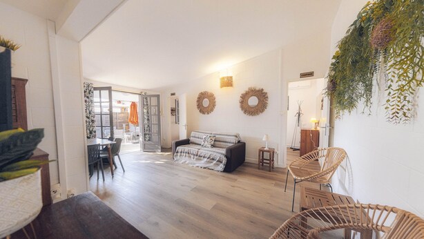 A spacious living area with a sofa, wicker chairs, and a dining table. - BUNGALOW T3 PITAYA (Saint-Paul)