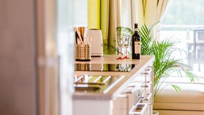 Une cuisine moderne avec un coin bar, une bouteille de vin et une plante.
