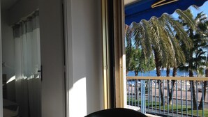 Une chambre avec vue sur les palmiers et un balcon.