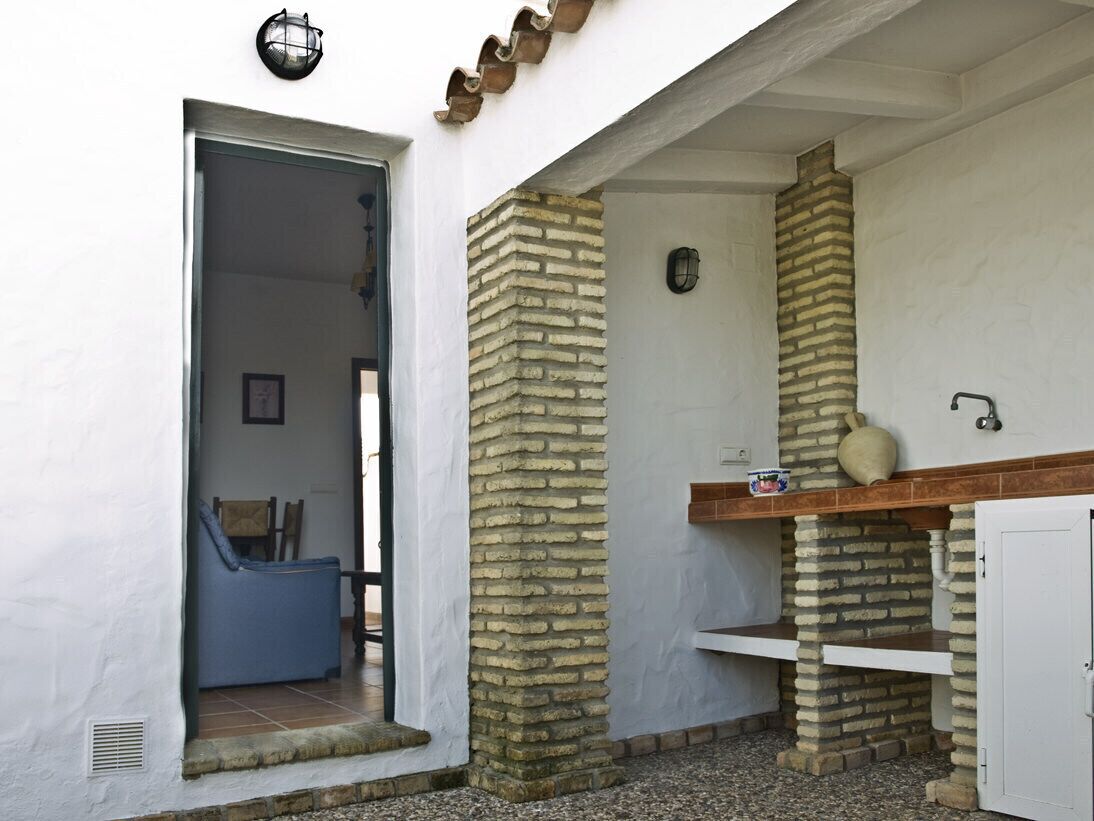 A bathroom with a stone wall, a sink, and a white cabinet.
