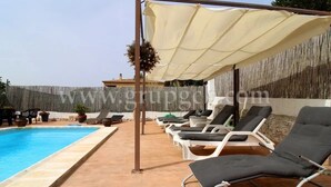 A poolside area with lounge chairs and a canopy.