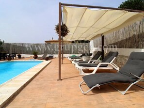 Area piscina con lettini e ombrellone.