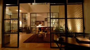 Relax in this stylish living space with a comfortable sofa set, dining table, and potted plants.