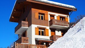 A multi-story wooden building with balconies, a wooden fence, and a snowy slope. - T2 / 36M² FOR 5 PEOPLE 100M FROM THE MECHANICAL RIDGE IN THE HEART OF PARADISKI (Peisey-Nancroix)