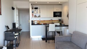 A compact living space with a kitchenette, a dining area, and a seating area. - Melo's Studio with amazing views of Cannes and the sea as well as WiFi (Cannes)
