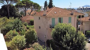 A residential building with a tiled roof, green shutters, and a balcony. - Melo's Studio with amazing views of Cannes and the sea as well as WiFi (Cannes)