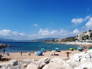A beach with rocky foreground, clear blue water, and buildings in the background. - Melo's Studio with amazing views of Cannes and the sea as well as WiFi (Cannes)