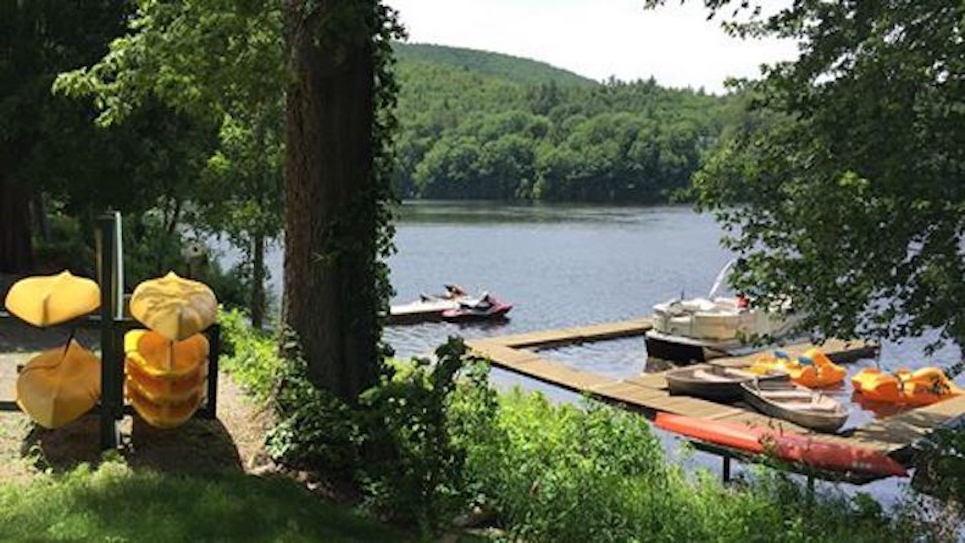 A lakeside dock with boats and a picnic table.