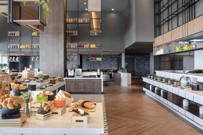 Un espace cuisine moderne avec un îlot central, des armoires en bois et un mur en briques.