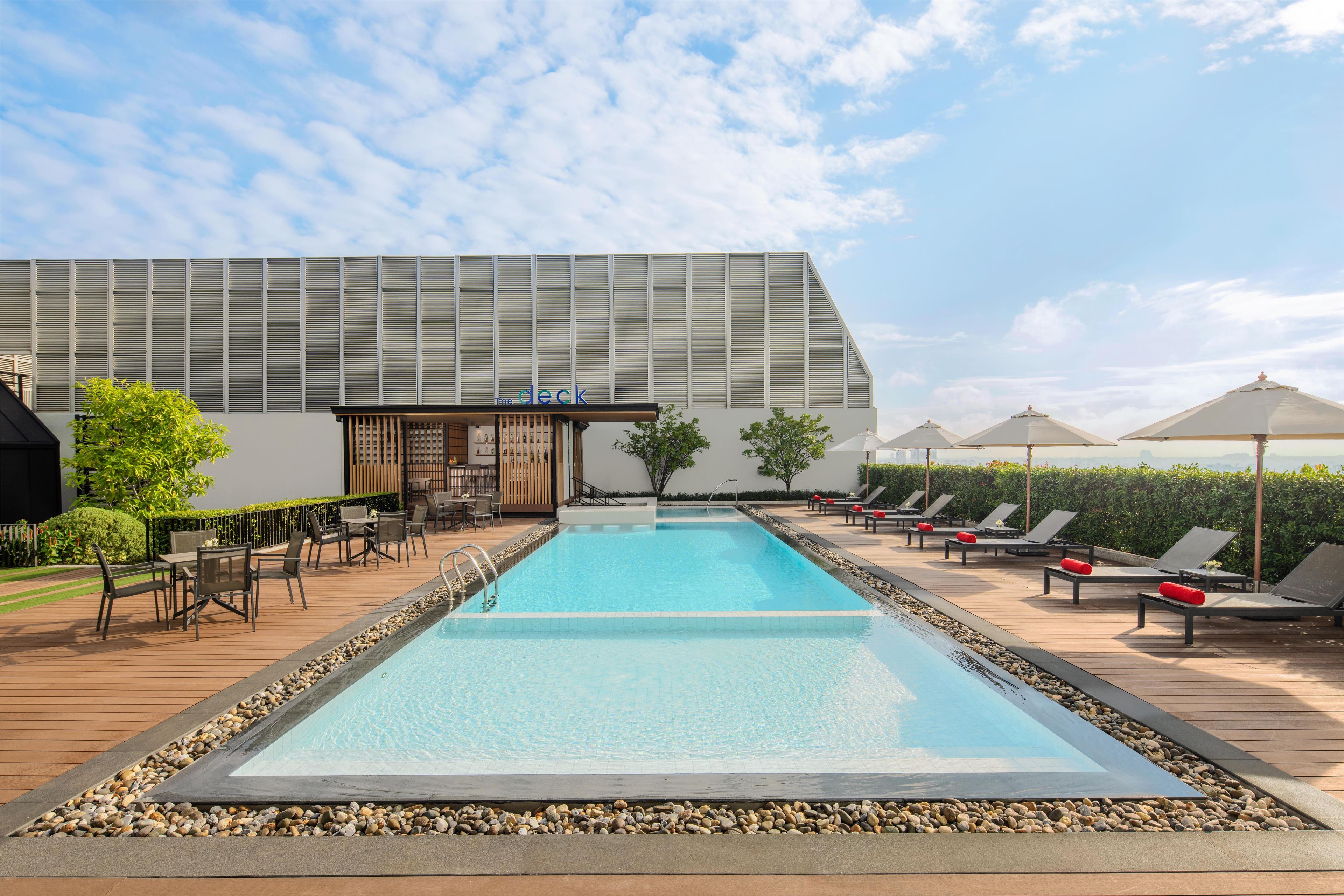 Une piscine avec des chaises longues et un espace bar.
