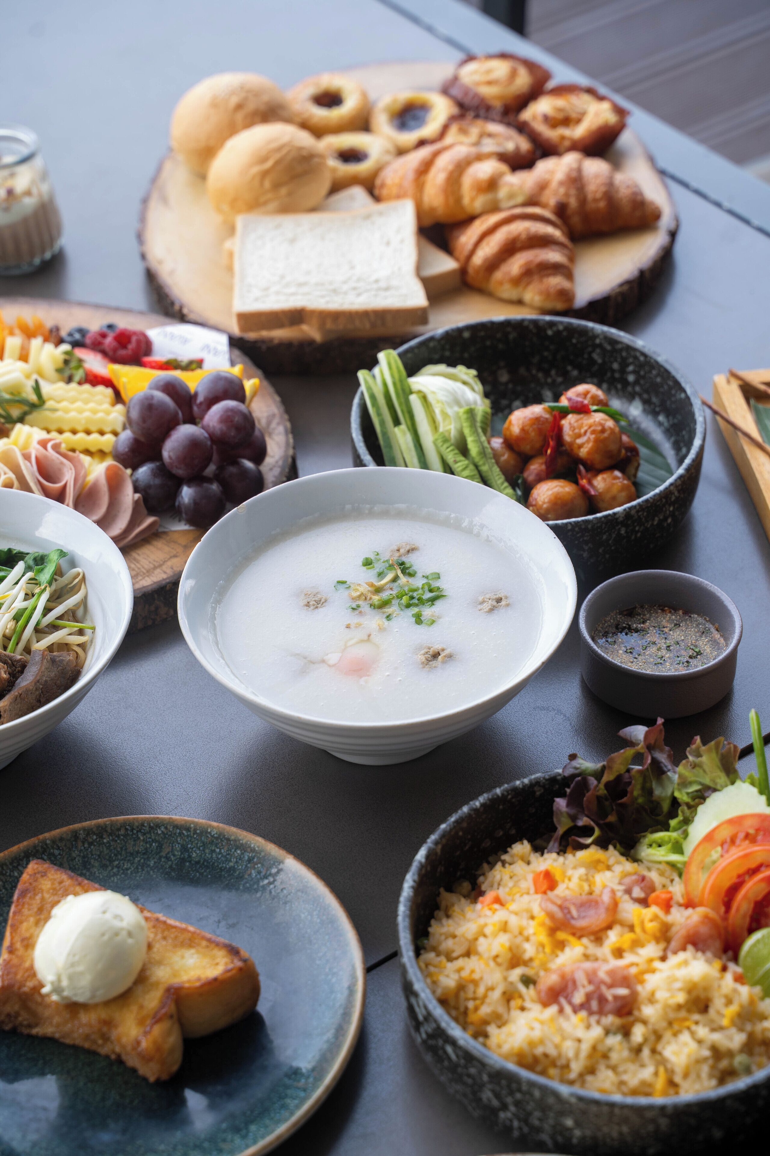 A table with various dishes including soup, bread, and pastries.