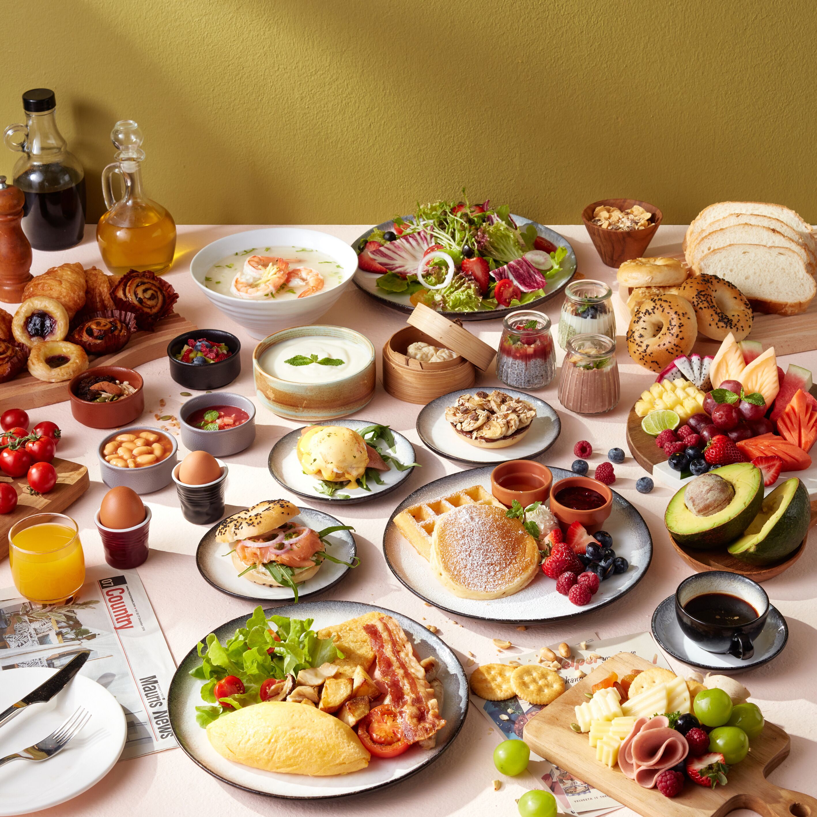 Una mesa con diversos productos para el desayuno, como pasteles, frutas y bebidas.