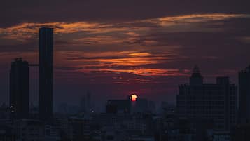 Un horizonte urbano al anochecer con altos edificios y un atardecer.