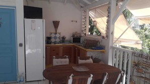 Eine kleine Küche mit Kühlschrank, Mikrowelle und Holzschränken.