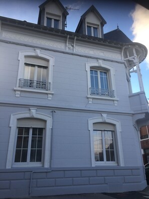 Ein weißes Gebäude mit drei Fenstern und einem Balkon.