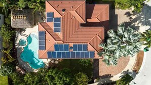 Eine Vogelperspektive zeigt ein Haus mit Schwimmbad, Solaranlage und Garten.
