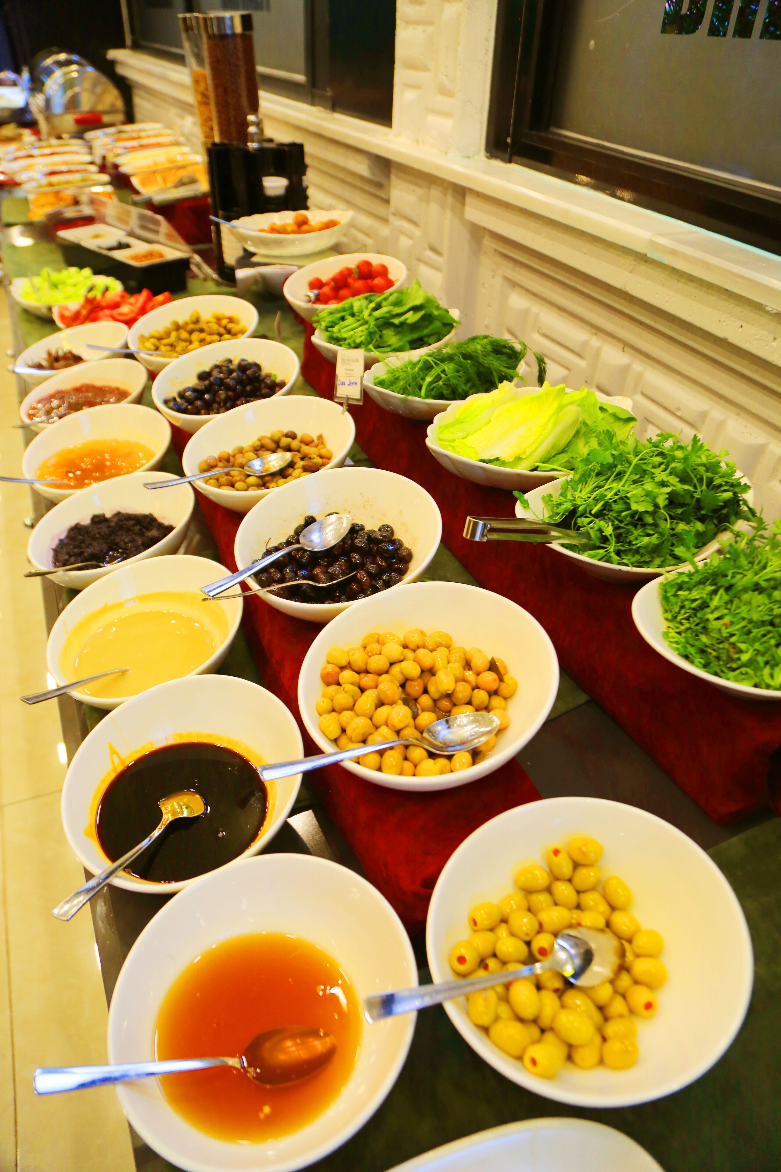 A buffet table with various food items and condiments.