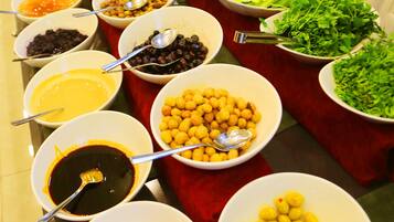 A buffet table with various food items and condiments.