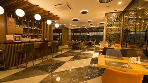 Un restaurant moderne avec un sol à carreaux, un bar en bois et différents types de sièges.