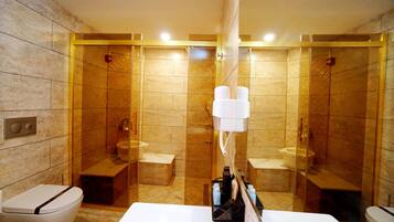 Un baño moderno con ducha de vidrio, lavamanos blanco y un inodoro.