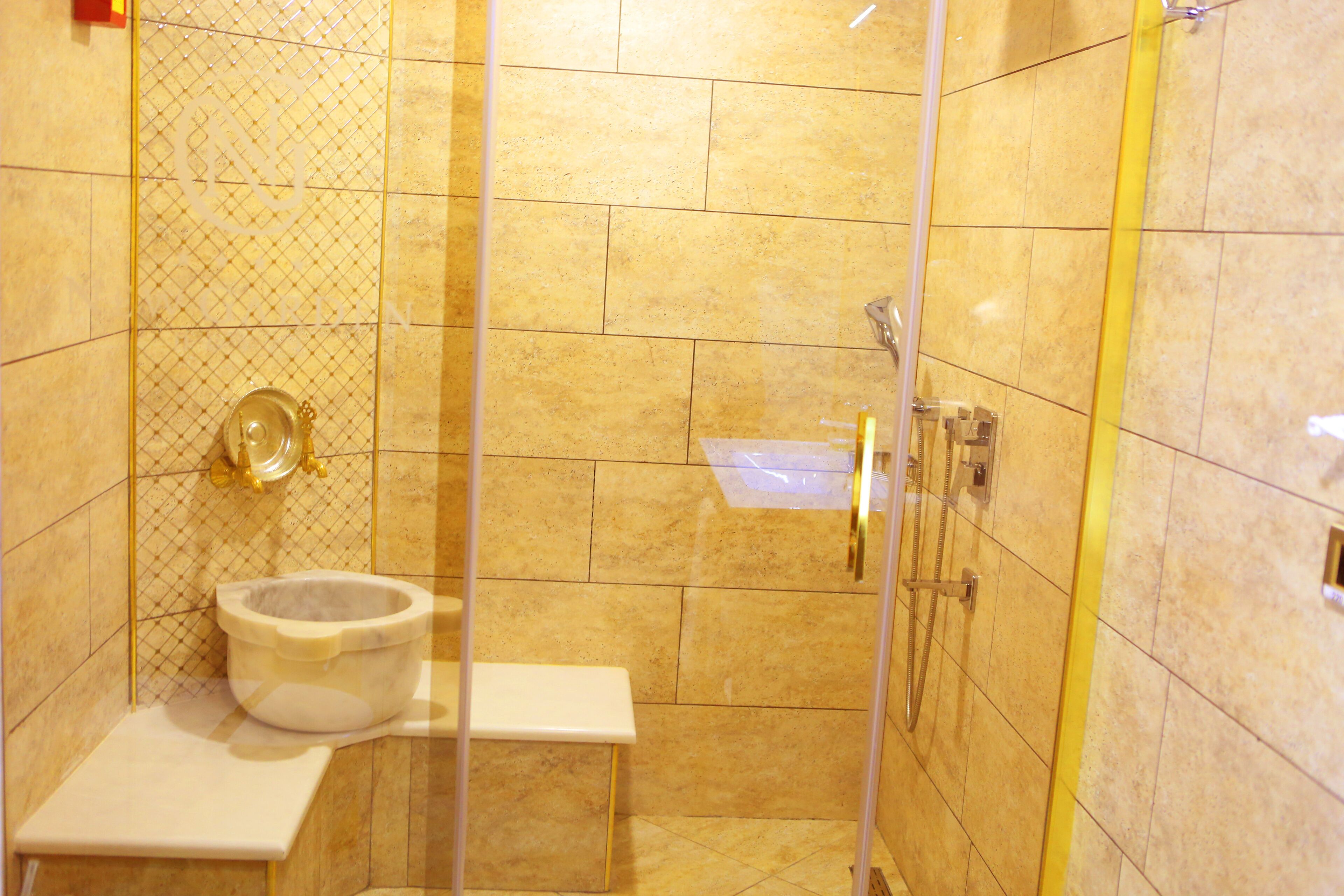 A shower area with a glass door, a white sink, and a toilet.