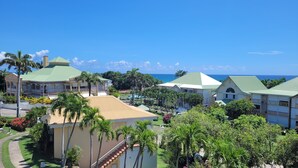A resort with multiple buildings, palm trees, and a view of the ocean. - Anse des rochers - Studio Cashew (saint-françois)