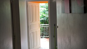 A hallway with a white door leading to a balcony. - HIBISCUS HOUSE 2 LARGE BEDROOMS with bathroom (Le Gosier)