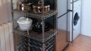 Una estantería metálica con varios utensilios de cocina.