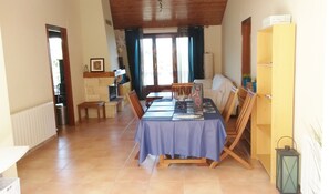 A dining area with a table set for four, a wooden bench, a bookshelf, and a radiator. - HOLIDAY HOUSE WITH PRIVATE POOL, SPECTACULAR SEA AND MOUNTAIN VIEW (Can Palau)