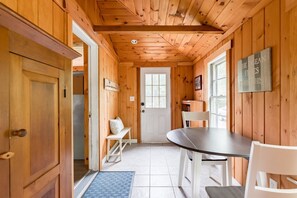 Cozy cabin interior with a warm atmosphere, featuring a dining area and seating space.