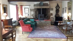 A cozy living room with a fireplace, a sofa, and a television. - Morbihan 15 km sea, beautiful farmhouse 9personnes (Berric)