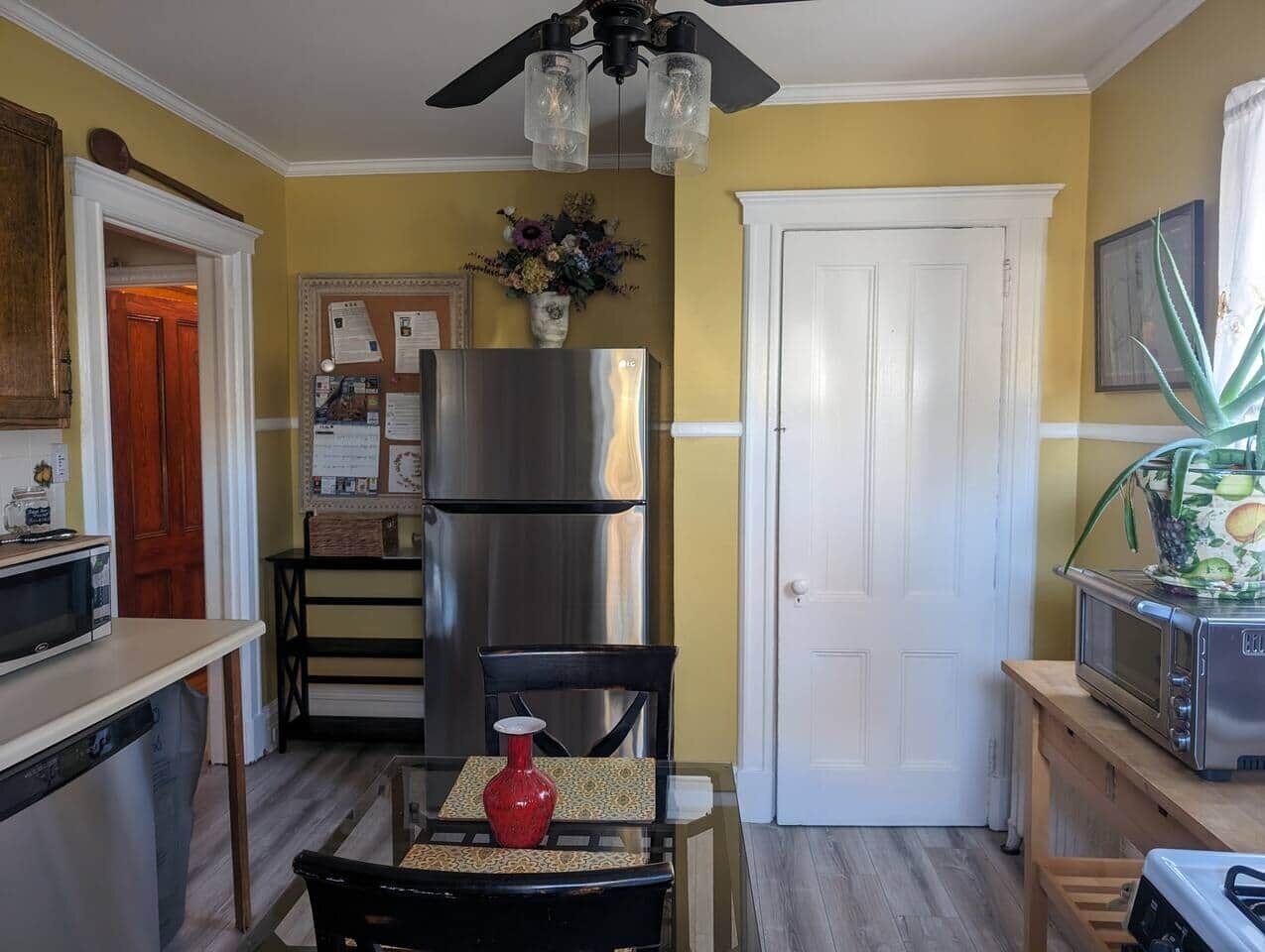 Eine kompakte Küche mit Kühlschrank, Mikrowelle und einem Essbereich mit Stuhl und Tisch.