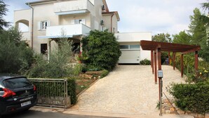 Una casa de dos pisos con un camino de piedra que lleva a una entrada con portón.