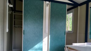 Una stanza con una porta scorrevole, una scrivania bianca e una sedia.