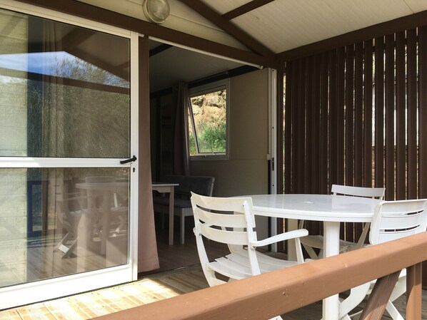 An open sliding door leading to a patio area with a table and chairs.