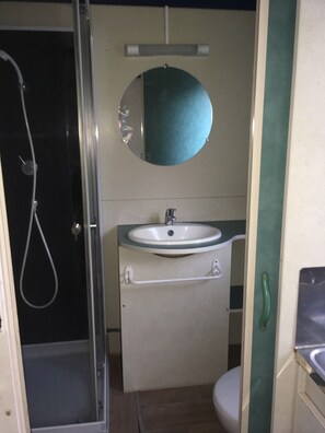 Ein Badezimmer mit Dusche, Waschbecken und Toilette.